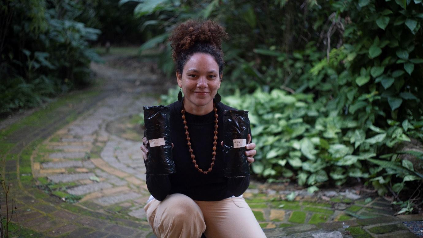 Silvia segurando as mudas das sementes nativas recém-plantadas